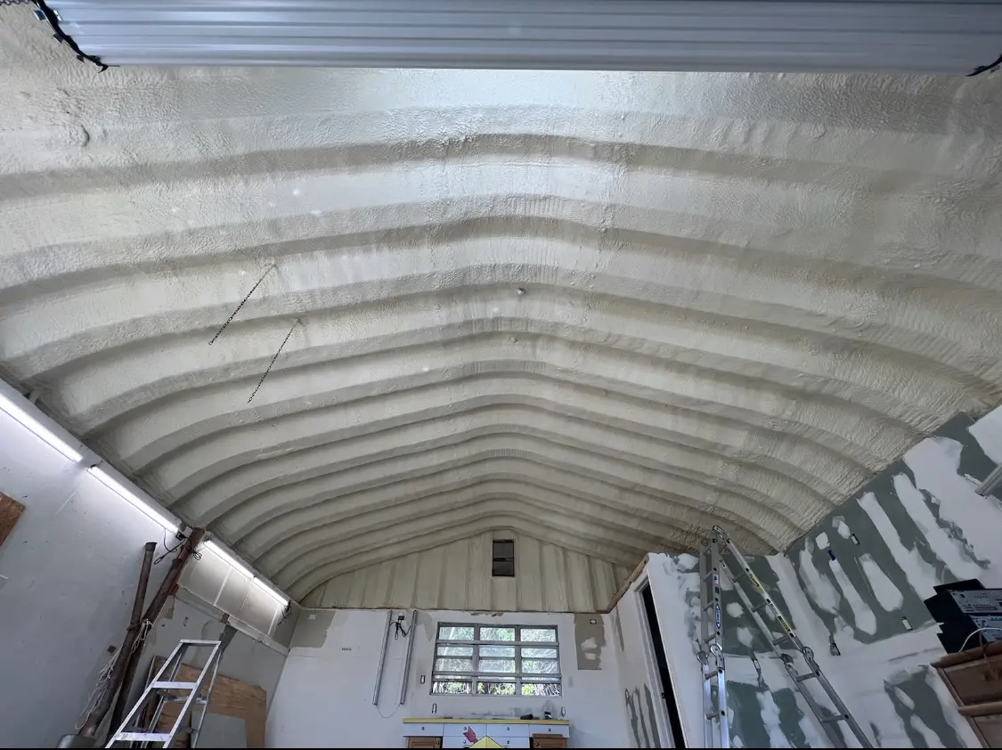Spray polyurethane foam applied to the underside of a metal roof deck in Brick